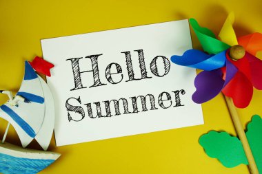 Sarı arkaplanda renkli fırıldak manzaralı kağıt kart üzerindeki yaz metni.