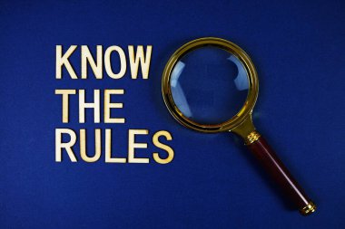 Lacivert arka planda büyüteç olan Kurallar alfabesi harflerini biliyor musun?