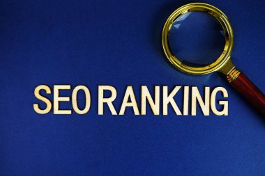 SEO sıralı alfabe harfleri ve lacivert arka planda büyüteç.