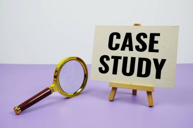 Kağıt üzerinde çalışma metni ve mor zemin üzerinde büyüteç