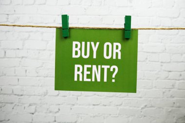 Alayım mı kiralayayım mı? Beyaz tuğlalı arka planda iple asılı yeşil kağıt üzerinde metin