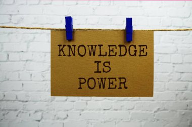 Bilgi beyaz tuğla arka planda halatla asılı kağıt üzerinde güç metni