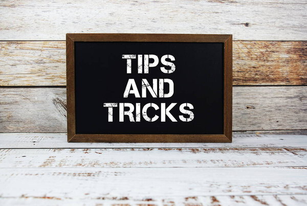 Tips and Tricks typography text on wooden blackboard