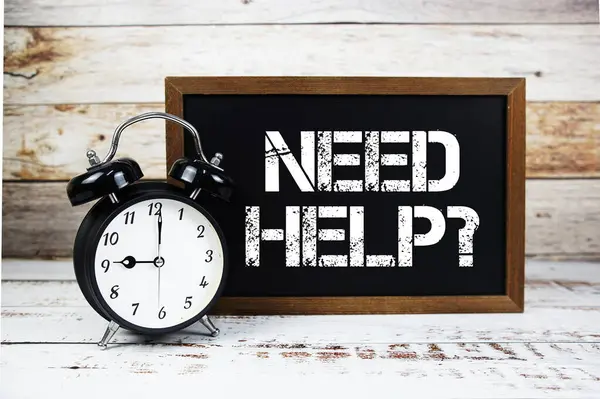 Yardım lazım mı? Tahta arkaplanda metin mesajı ve alarm saati