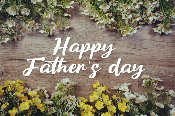 Babalar Günü mesajınız kutlu olsun. Ahşap arka planda çiçek süslemesi var.