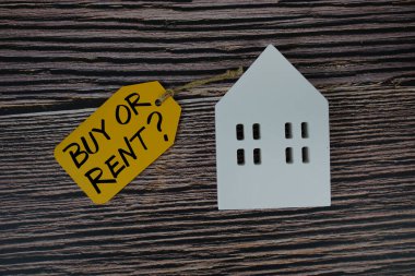 Almak mı, kiralamak mı? Beyaz Saray modeli düz ile fiyat etiketi üzerine metin ahşap zemin üzerinde yatıyordu