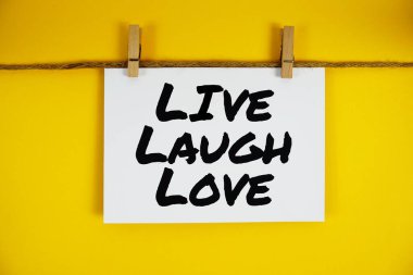 Sarı arkaplanda kağıt üzerinde Live Laugh Love metni