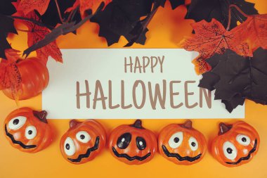 Turuncu arkaplandaki element dekorasyonlu Cadılar Bayramı metni