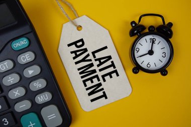 Alarm saati ve sarı arkaplanda hesap makinesi ile fiyat etiketi üzerine geç ödeme metni