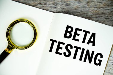 Tahtaya yazılmış Beta Deneme metni ve ahşap arkaplanda alarm saati