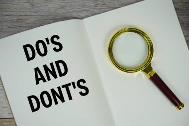 Do 's And Dont' un tahtaya yazılmış metni ve ahşap arka planda çalar saat.
