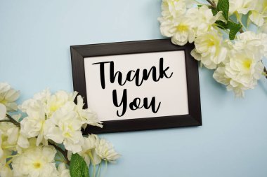 Açık mavi arkaplanda çiçek süslemeli teşekkür mesajı