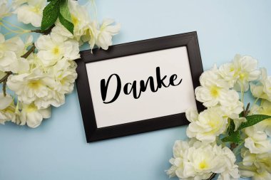 Açık mavi arkaplanda çiçek desenli teşekkür metni