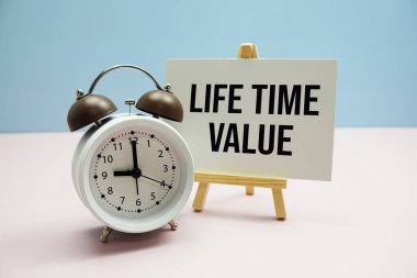 Kağıt üzerinde Pembe zemin üzerinde alarm saati olan Yaşam Saati Değeri metni