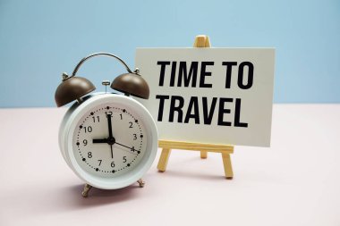 Kağıt üzerinde pembe zemin üzerinde alarm saati olan metni seyahat etme zamanı