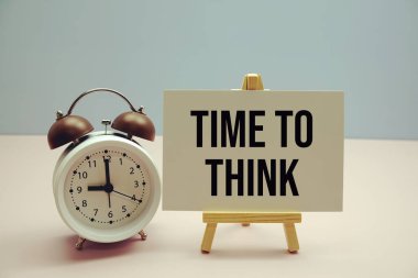 Kağıt üzerinde pembe zemin üzerinde alarm saati olan metin düşünme zamanı