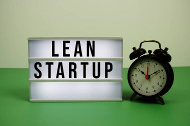 Yeşil arkaplanda alarm saati olan LED ışık kutusu üzerine başlangıç metni