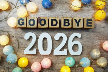 Elveda 2026 yılı LED pamuk topları dekorasyonlu ahşap arka planda üst görünüm