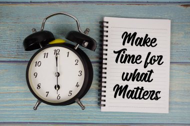 Matters 'ın not defterine ne yazdığı ve alarm saatiyle ahşap arkaplanda ne yazdığı için zaman ayır