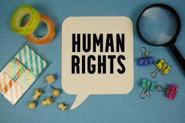 Mavi zemin üzerinde büyüteç bulunan İnsan Hakları metni