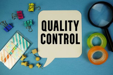 Mavi zemin üzerinde büyüteç bulunan Kalite Kontrol metni