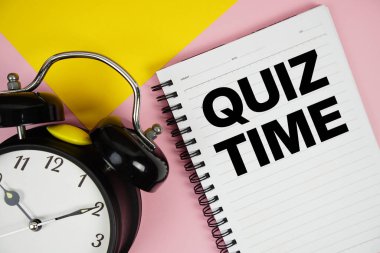 Not defterinde pembe zemin üzerinde alarmlı saat yazılı Sınav Zamanı metni