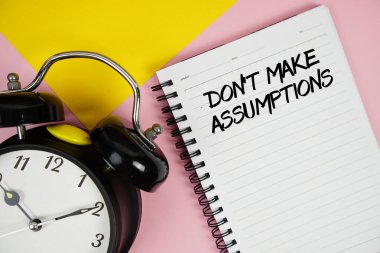 Not defterine pembe arkaplanda çalar saat yazılı varsayımlar yazma