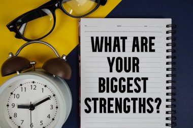 En büyük güçlerin nelerdir? Mavi arkaplanda alarm saati olan not defterine yazılan metin