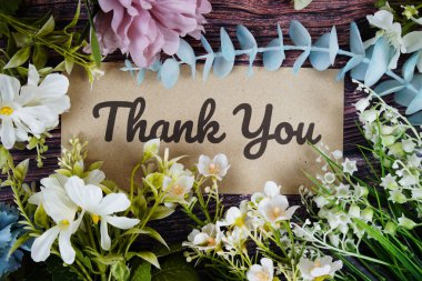 Ahşap arka planda çiçek buketi desenli teşekkür mesajı