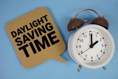 Mavi arkaplanda alarm saati olan Gün Işığı Tasarruf Zamanı metni