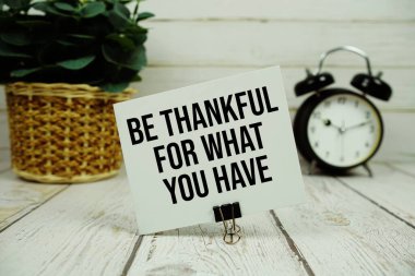 Kağıt üzerinde, ahşap zemin üzerinde çalar saat olan metnin için şükret.