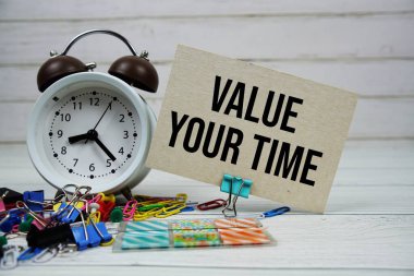 Zaman metninizi alarm saati ve ahşap zemin üzerinde durağan olan kağıt kart üzerinde değerlendir