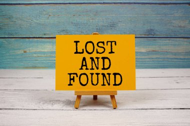 Kayıp ve Bulunmuş metni tahta arkaplanda kağıt karta yazılmış.