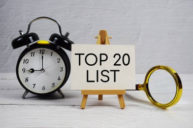Alarm saati ve tahta zemin üzerinde büyüteç bulunan ilk 20 Liste metni