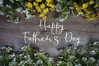 Babalar Günü mesajınız kutlu olsun. Ahşap arka planda çiçek süslemesi var.