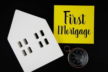 Siyah zemin üzerinde ev modeli ve pusula olan ilk ipotek metni