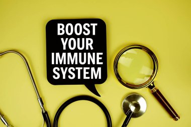 Bağışıklık Sistemi mesajınızı kağıt kartta steteskop büyüteçle sarı arkaplanda yükseltin