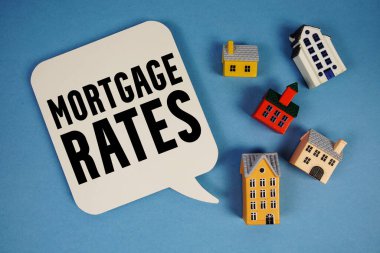 İpotek Oranları mavi arkaplanda ev modelleri ile metin