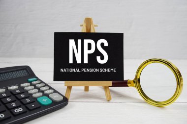 NPS abbreviation of National Pension Scheme text with magnifying glass and calculator on wooden background