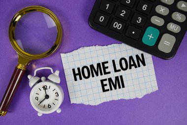 Home Loan EMI text with alarm clock, magnifying glass anc calculator on purple background