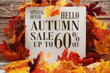 Sonbahar İndirimi% 60 indirimli metin ve ahşap arka planda akçaağaç yaprağı süslemesi