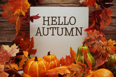 Ahşap zemin üzerinde akçaağaç yaprağı süslemesi olan sonbahar metni