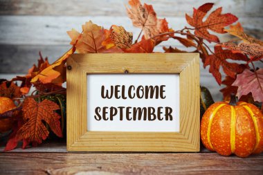 Ahşap zemin üzerinde akçaağaç yaprağı süslemesi olan Eylül ayına ait metin