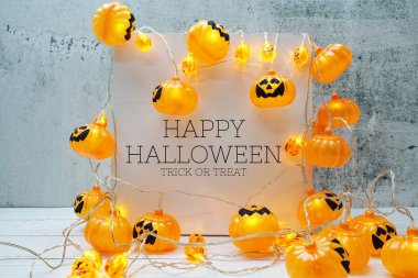 Ahşap zemin üzerinde LED balkabağı süslemesi olan Cadılar Bayramınız kutlu olsun.