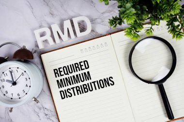 RMD - Required Minimum Distributions acronym on notepad, Business concept background