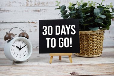 30 gün kaldı! Ahşap arkaplanda alarm saati olan metin