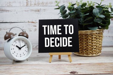 Tahta arkaplanda alarmlı saat ile metne karar verme zamanı