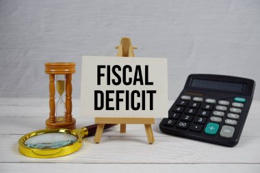 Tahta zemin üzerinde büyüteç ve hesap makinesi olan Mali Hasar metni