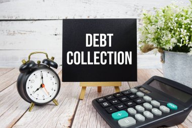 Ahşap zemin üzerinde alarm saati ve hesap makinesi olan borç toplama metni