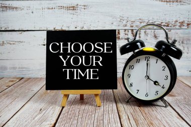 Ahşap zemin üzerinde sehpa ve alarm saati ile Zaman metninizi seçin